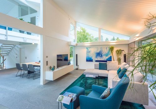 Helles und modernes Wohnzimmer mit eleganter Einrichtung Offener Wohnbereich mit hellen Farben, moderner Sofalandschaft und Kunstwerken