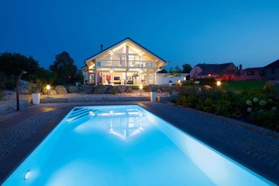 Fachwerkhaus HUF HAUS ART 4 bei Nacht Moderne Architektur mit Swimmingpool und Gartenbeleuchtung