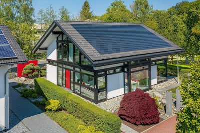 Moderne Villa mit Solaranlage und Garten Ansicht einer modernen Villa mit Solarpanelen und gepflegtem Garten