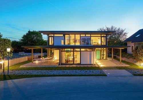 Moderne Architektur bei Dämmerung Ansicht eines modernen Hauses mit großen Fenstern und Außenbeleuchtung