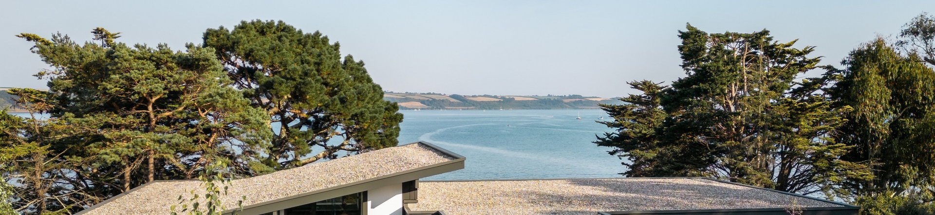 Spektakuläres Fachwerkhaus mit Meerblick Fachwerkhaus umgeben von Blumen und Bäumen mit Blick auf das Wasser