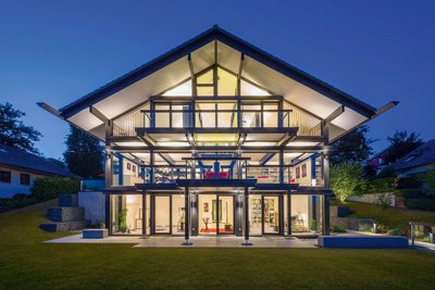 Modernes HUF Haus mit Glas-Architektur bei Nacht Architektenhaus mit Fachwerk-Design, offenes und helles Innenleben